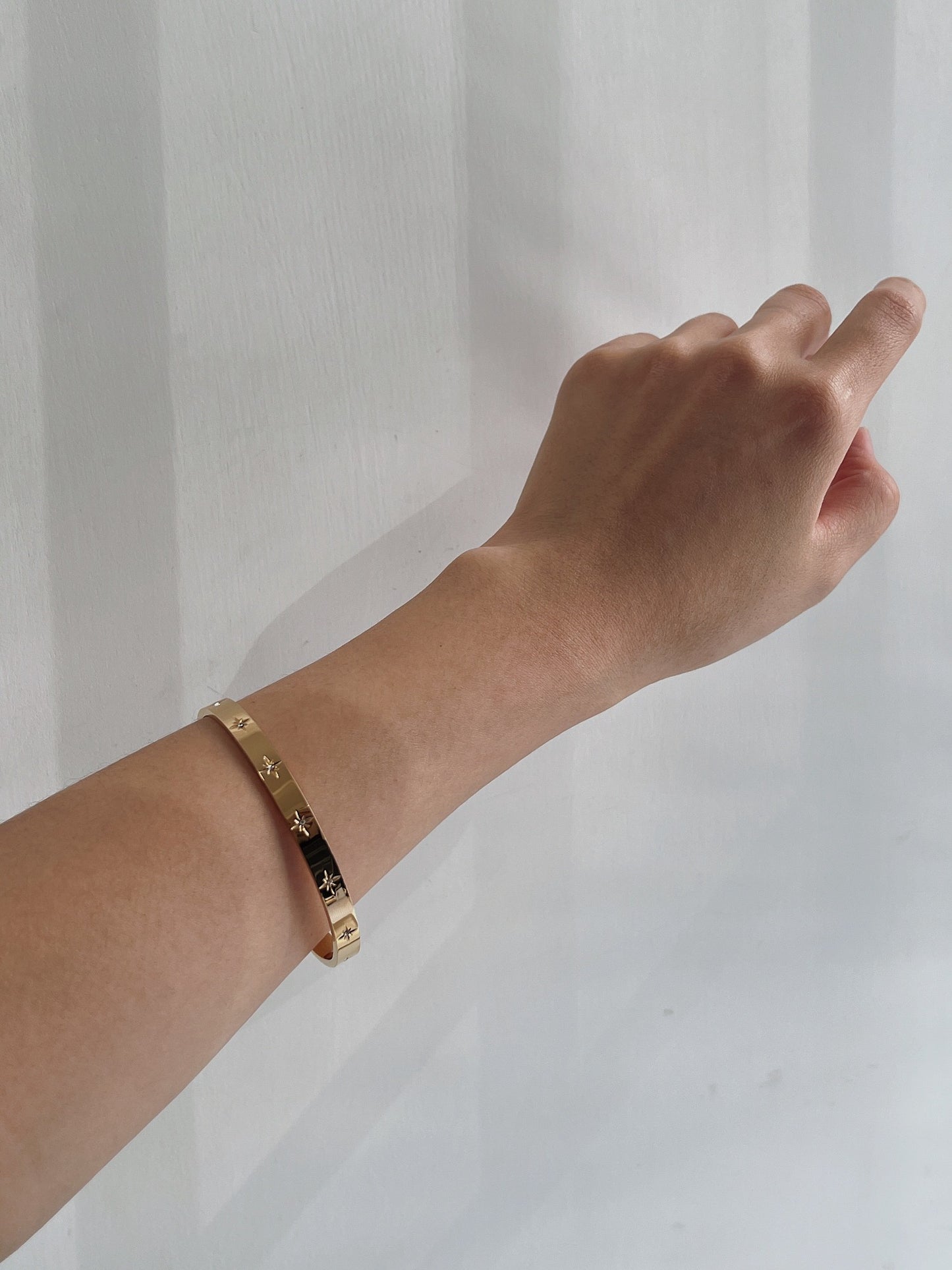 Gold bangle bracelet with star designs, premium jewelry for women, perfect for any occasion.