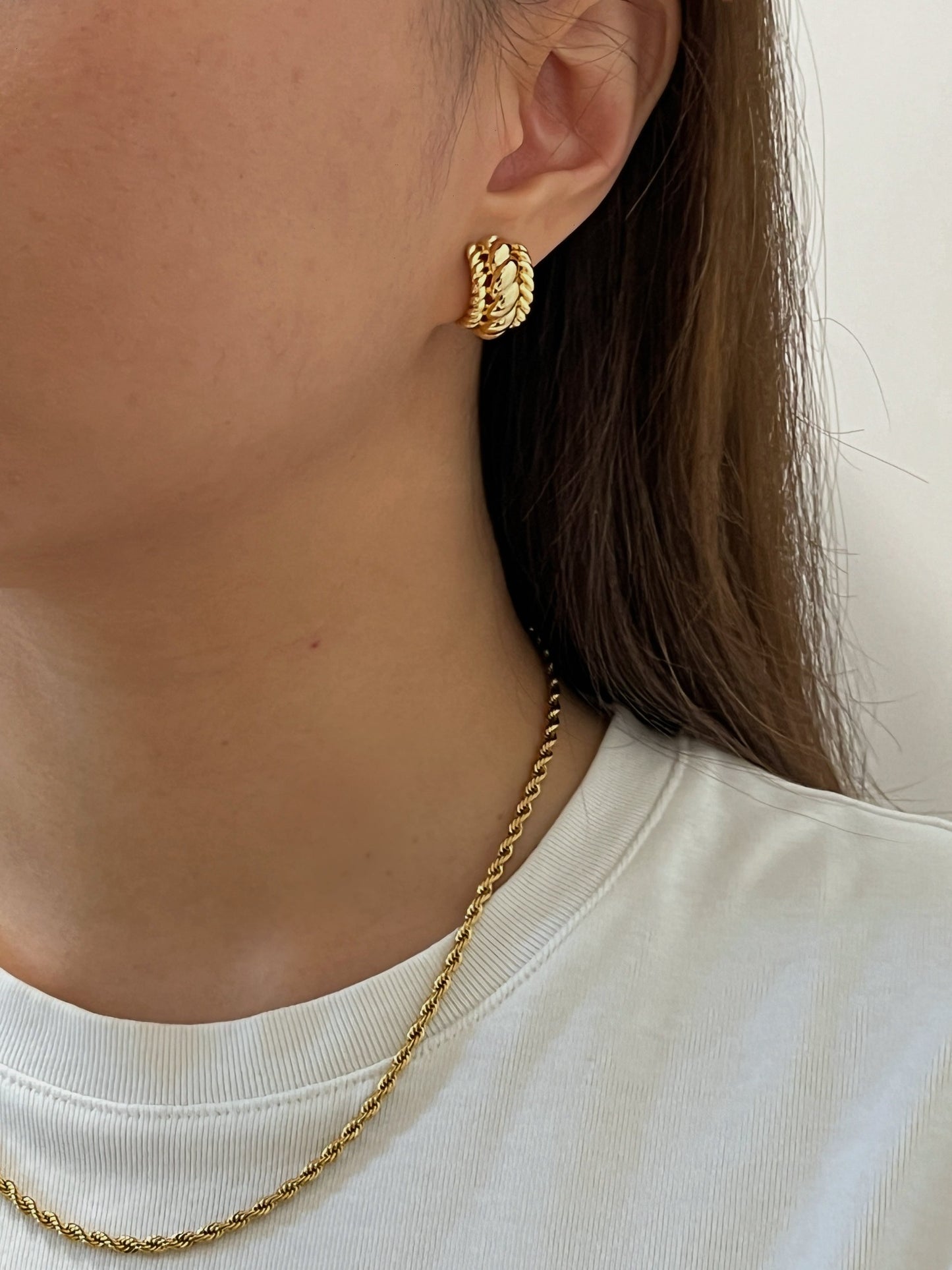 Trendy gold clip-on earrings with a captivating twisted design, ideal for accessorizing day or night.