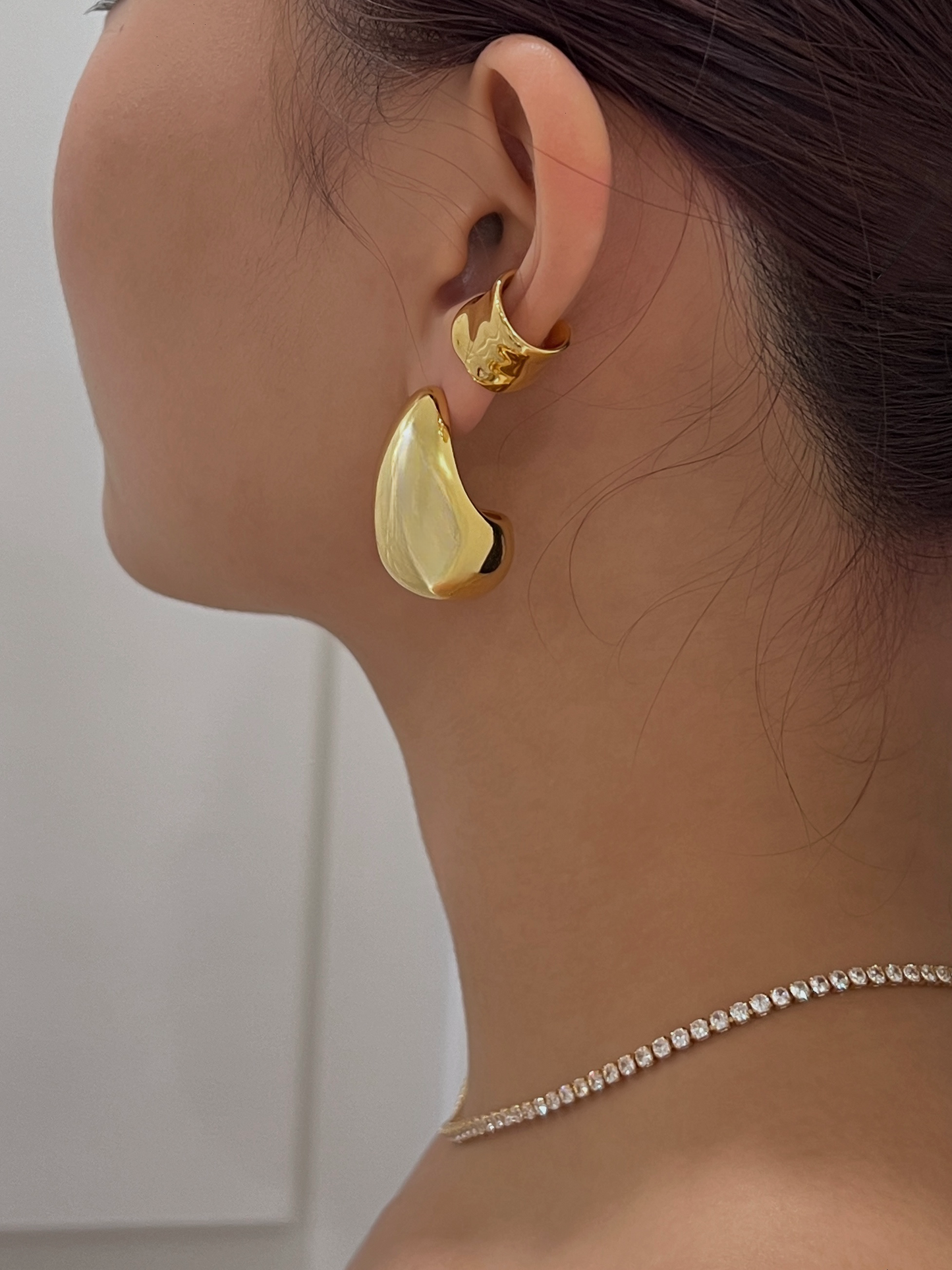 Elegant gold ear cuffs with modern wavy pattern.