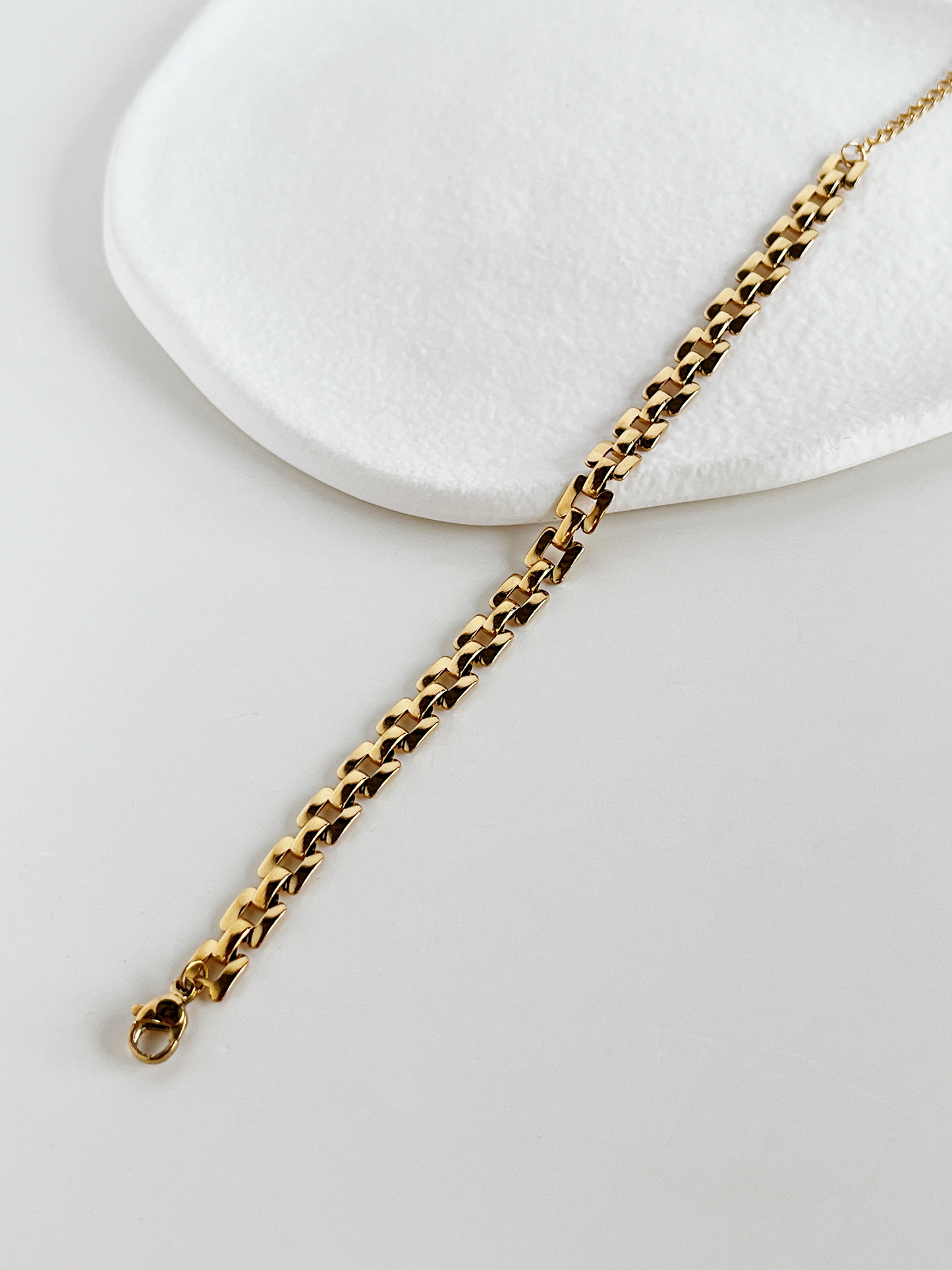 Top view of the gold Evie lightweight watchband chains laid flat on a neutral background to display the slender, uniform width.