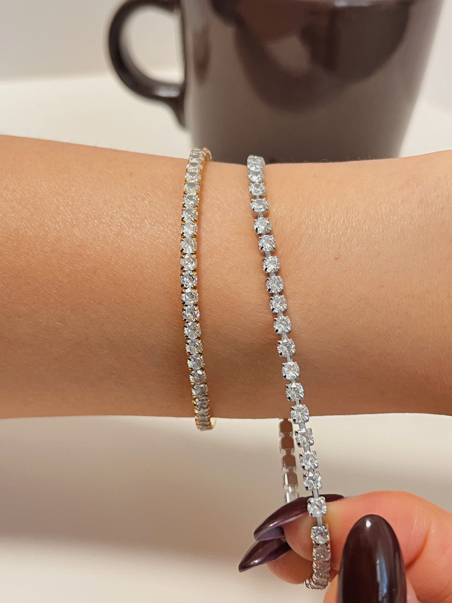 Wrist shot of a woman wearing and showcasing 2 pieces of waterproof elastic tennis bracelet.
