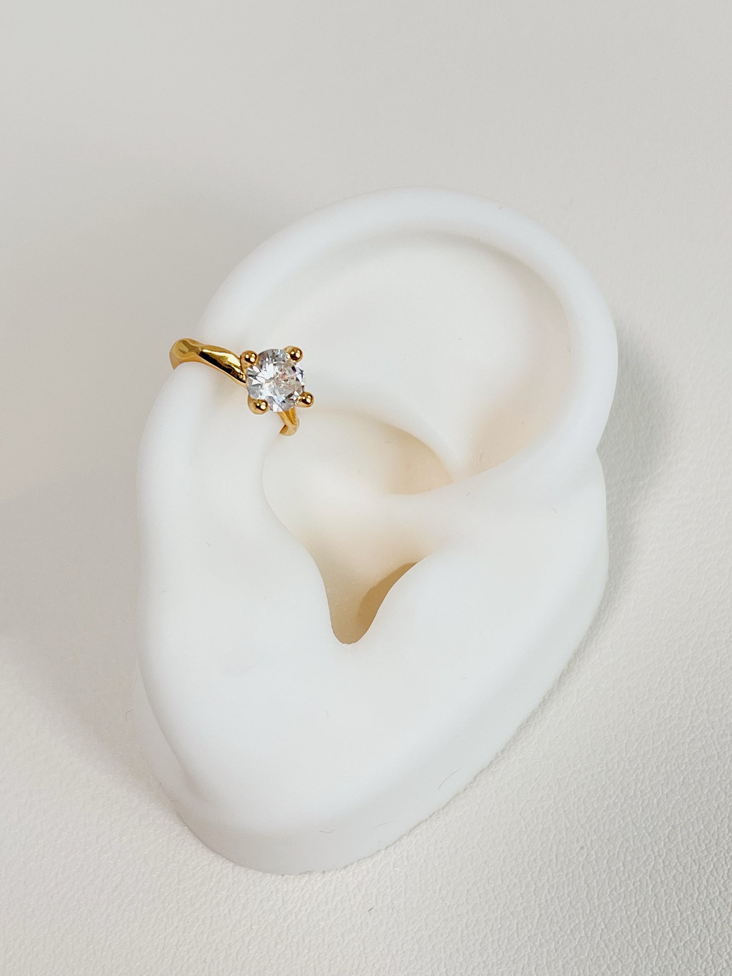 Minimalist aesthetic of gold round-cut ear cuff.
