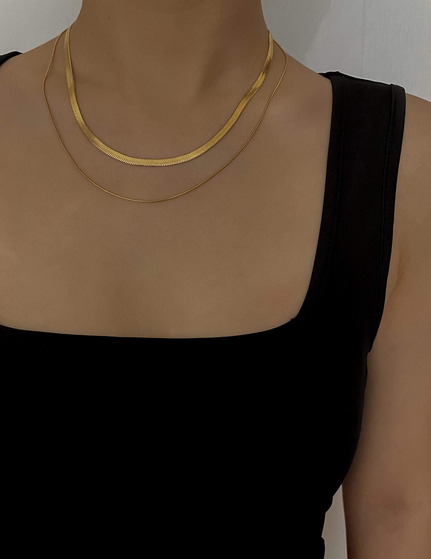 Sophisticated front perspective view showing how flat gold chain lie smooth on the collarbone