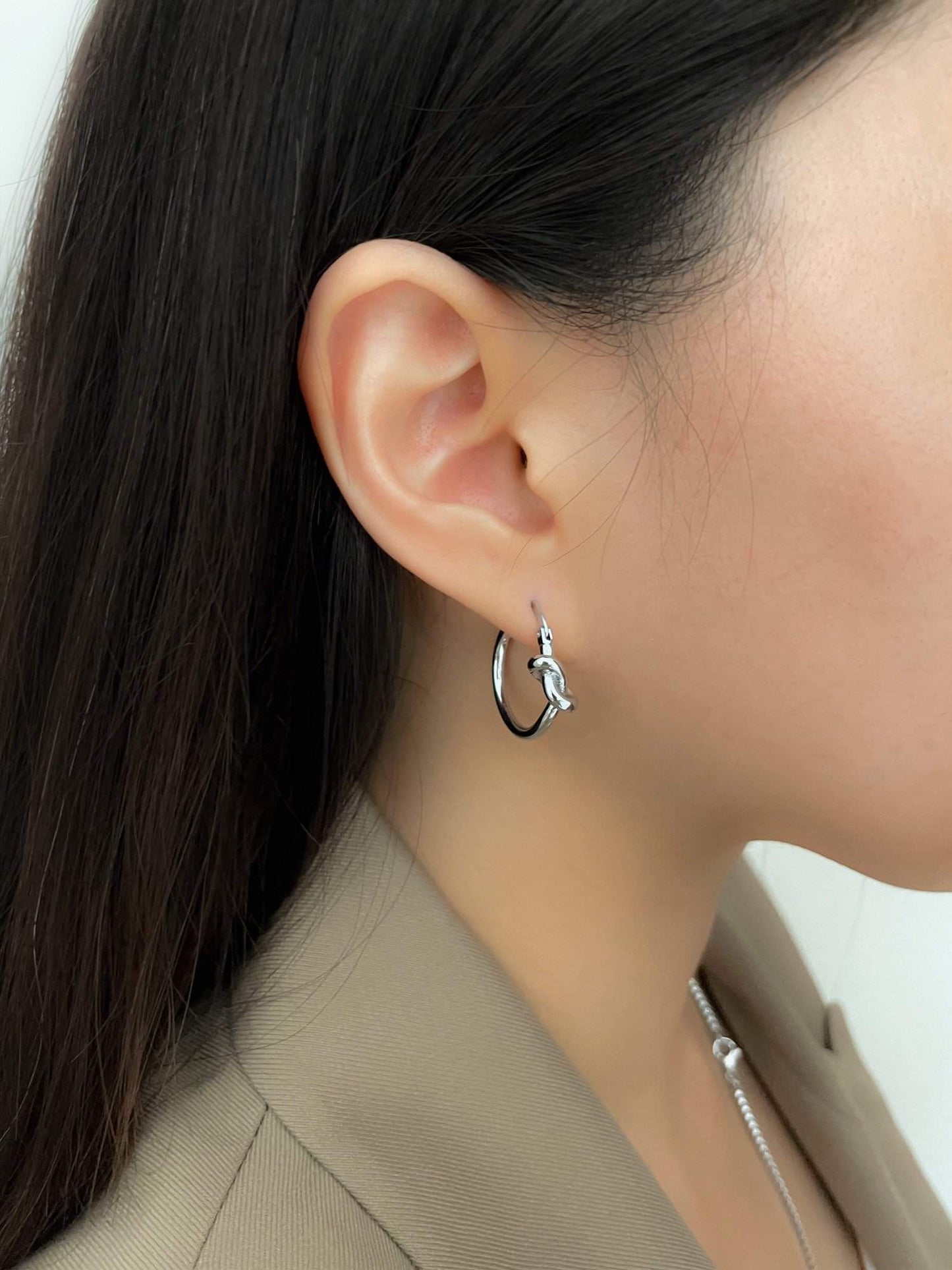 Silver hoop earrings with a trendy knot design