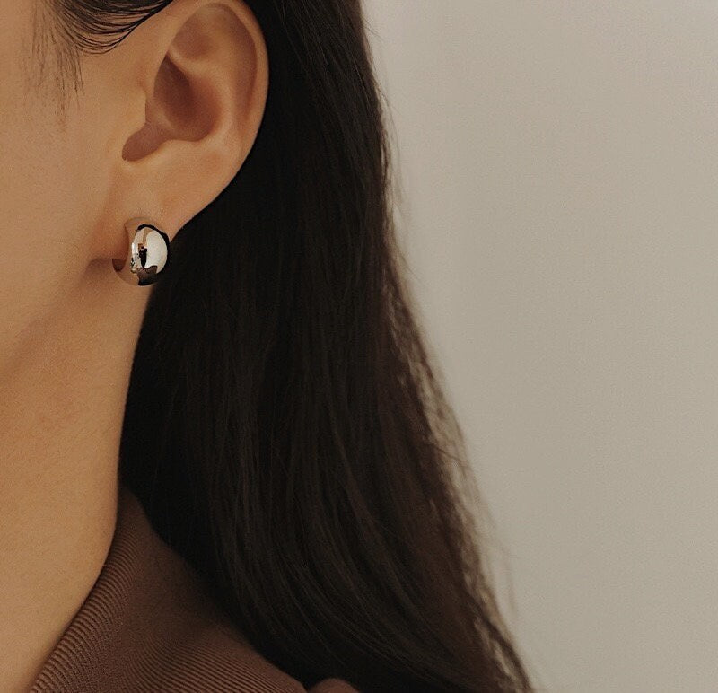 Stylish and modern silver huggie hoop earrings, ideal for adding a touch of elegance.