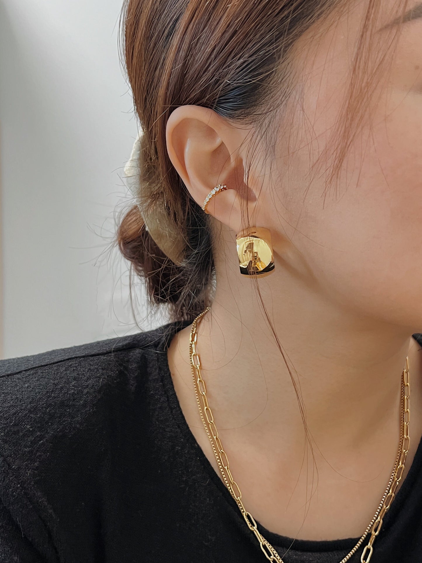 Fashionable and sleek gold hoop earrings, perfect for adding a touch of glamour to any outfit.