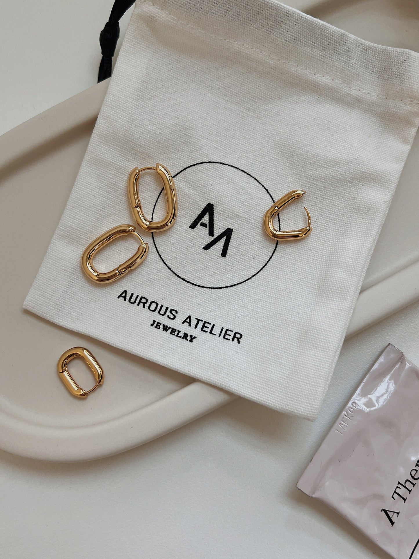 Mini gold rectangular hoop earrings, dainty and versatile, perfect for any occasion.