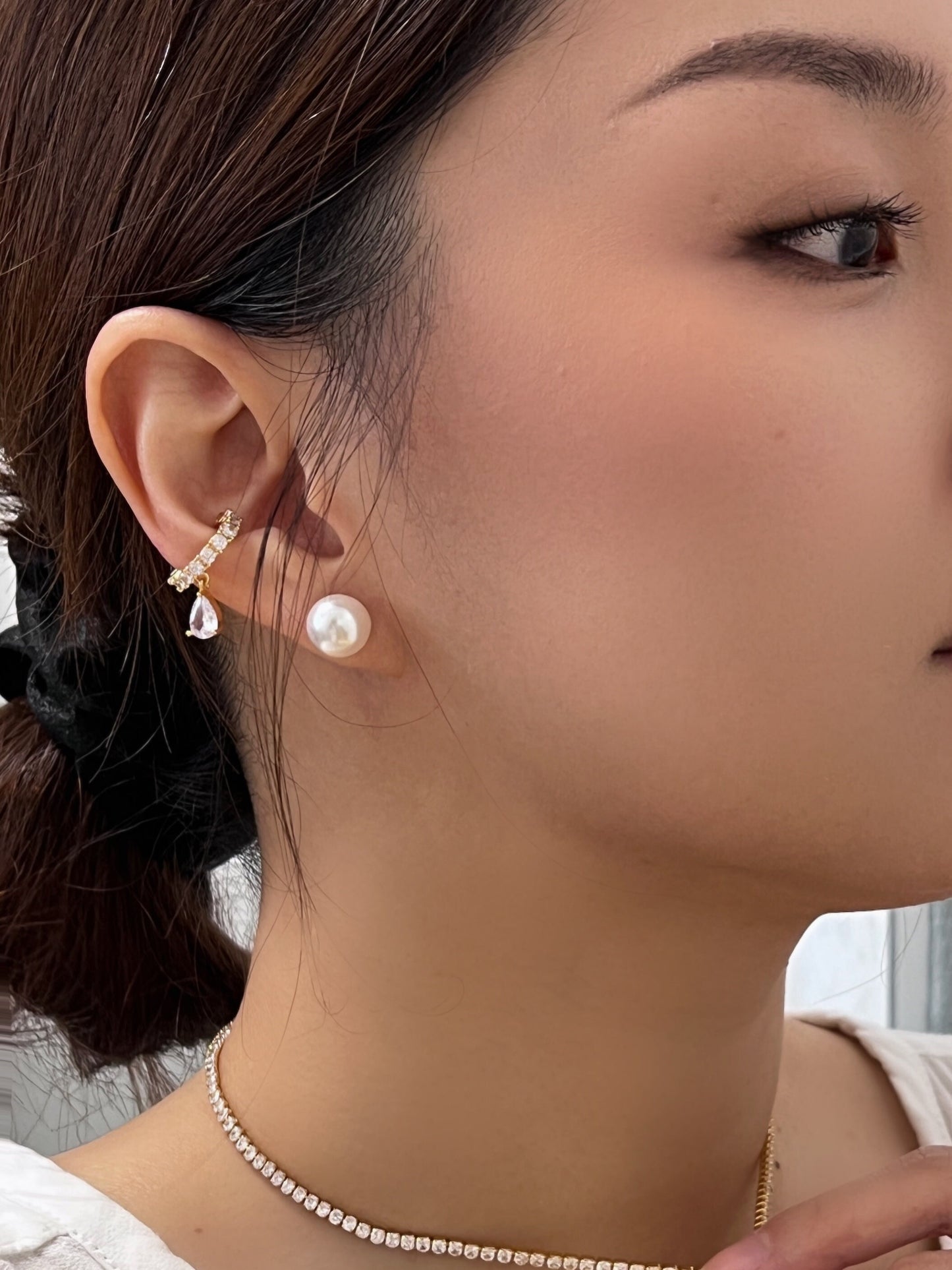 Gold ear cuff with teardrop diamond, a stunning addition to any high-end jewelry collection.
