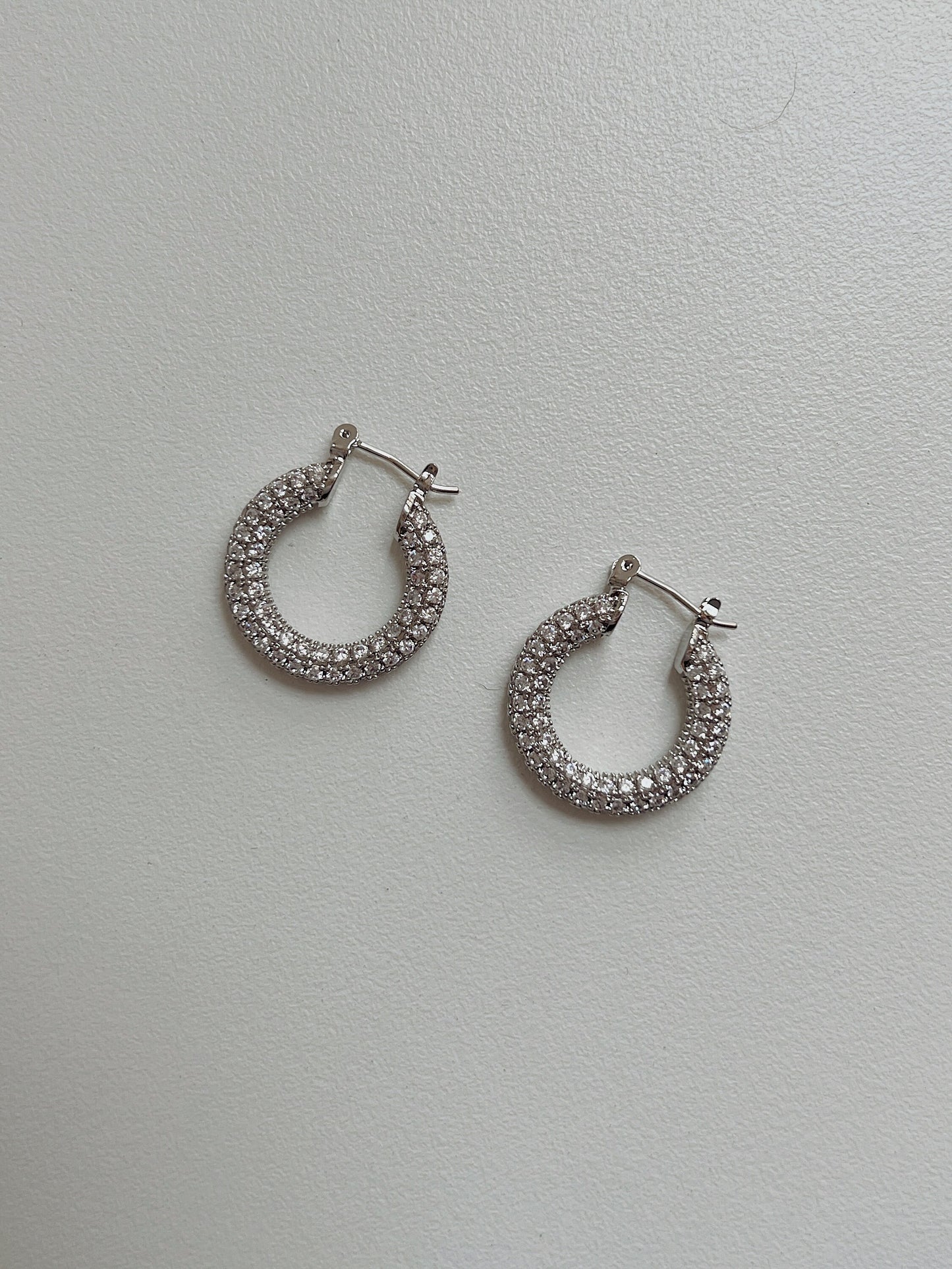 Stylish silver hoop earrings with sparkling stones for a touch of elegance.