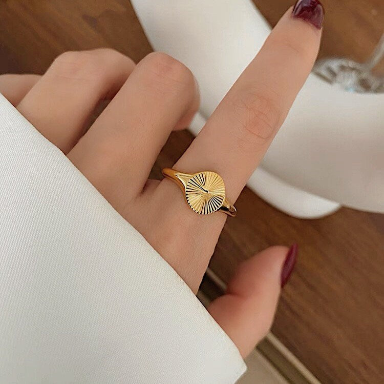 Hand model wearing gold signet ring as index finger ring