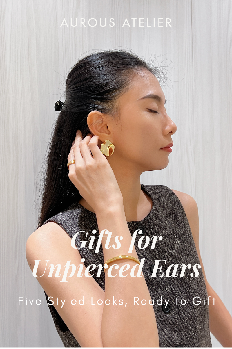 Woman touching her dark hair wearing a gold sculptural clip-on earring, with the text Gifts for Unpierced Ears.