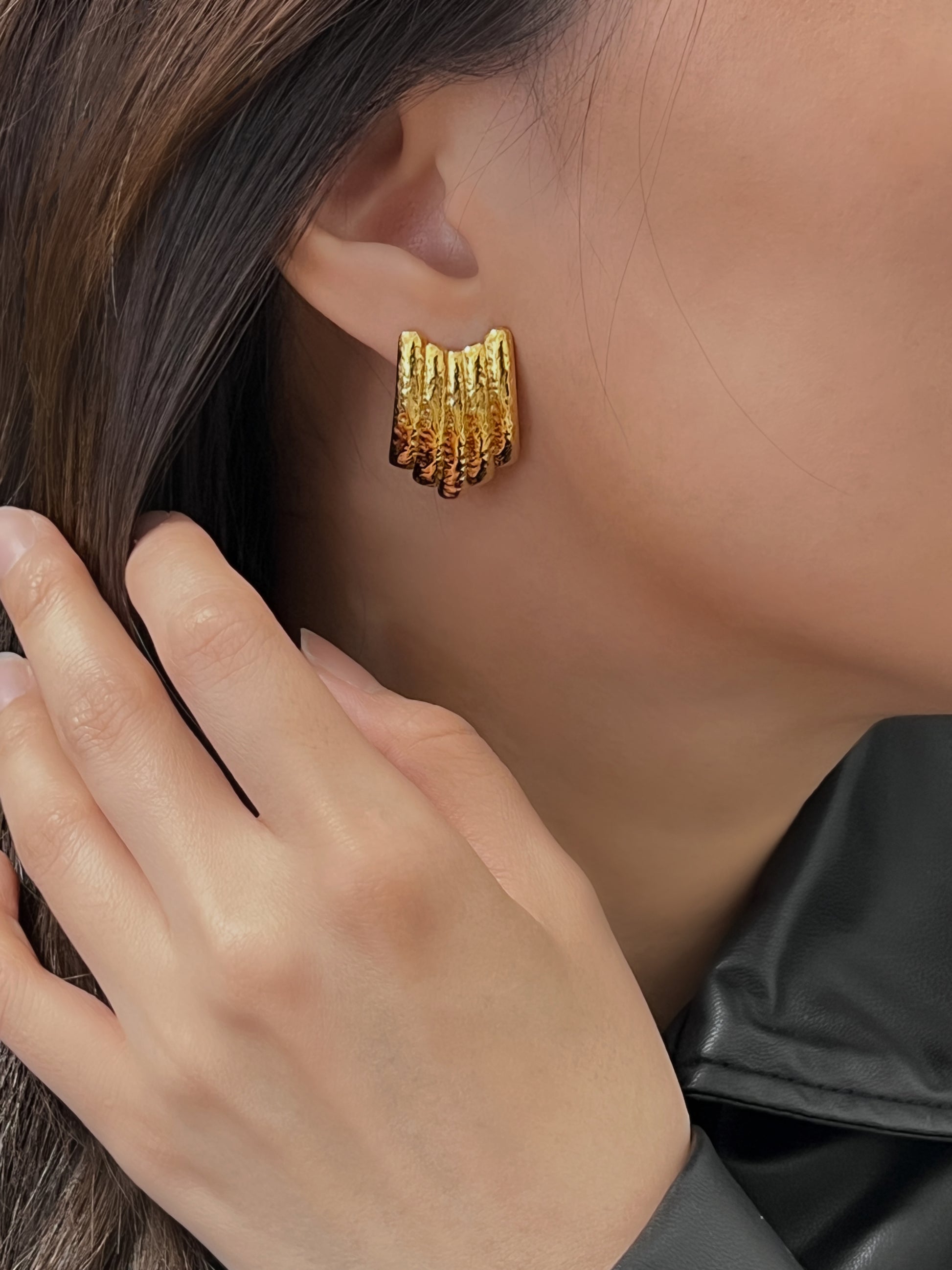 Stylish gold earrings with multiple layers and hammered design.