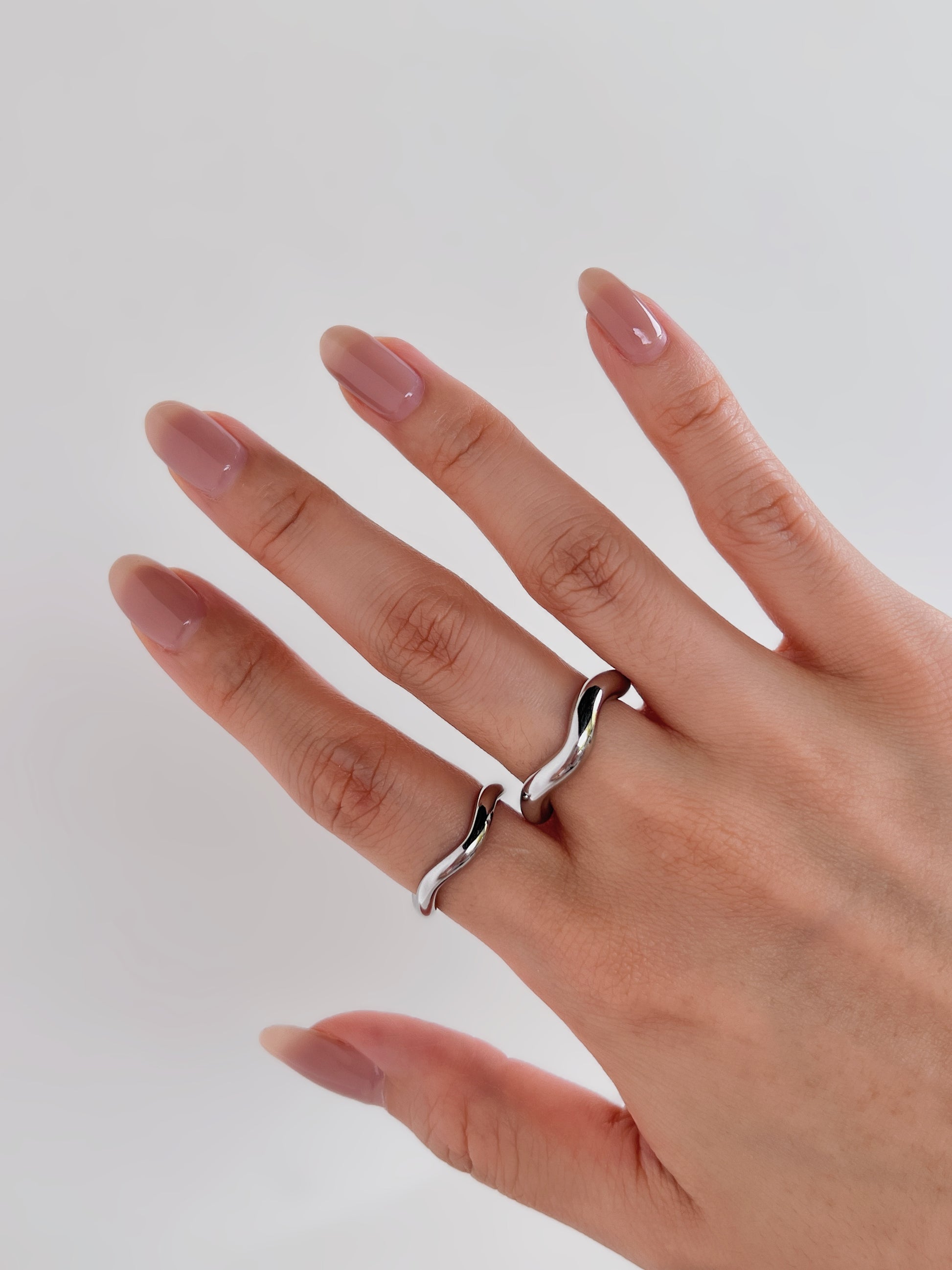 Sleek silver minimalist wave ring on hand