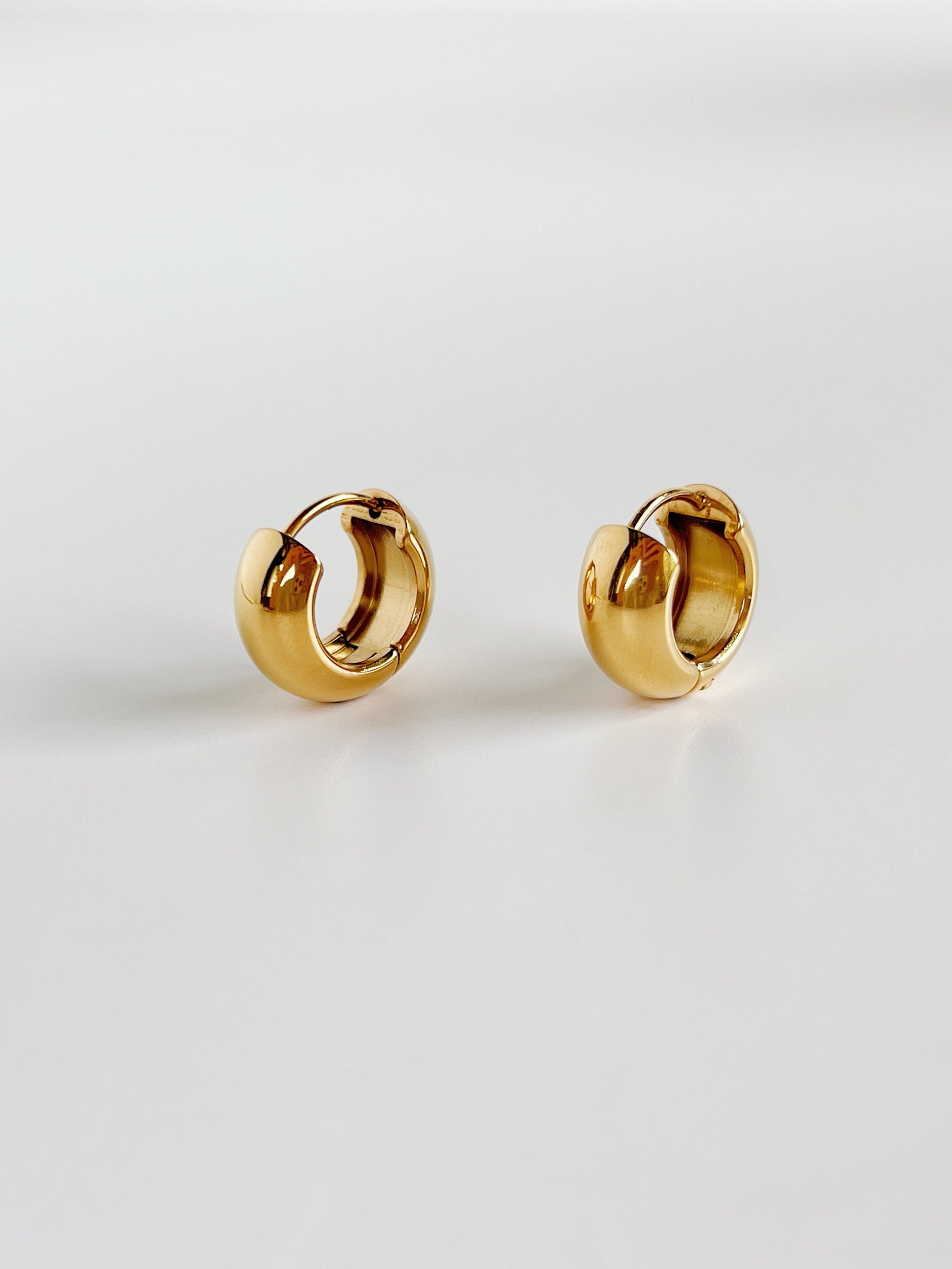 Pair of gold hoop earrings on a light gray background