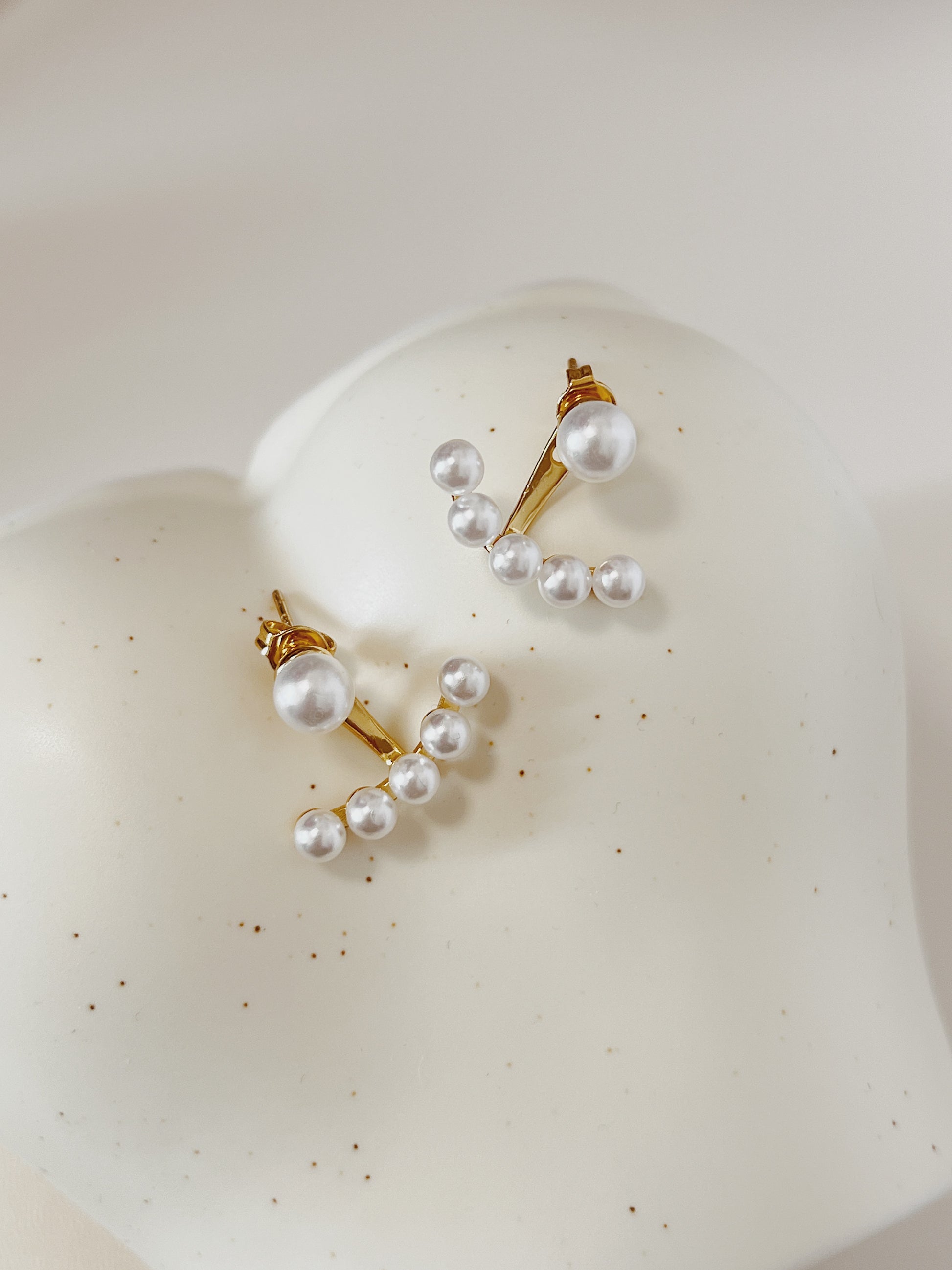 Pearl earring on a white surface