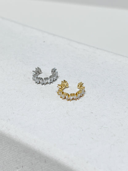 Gold and silver diamond cuff earrings on a light background