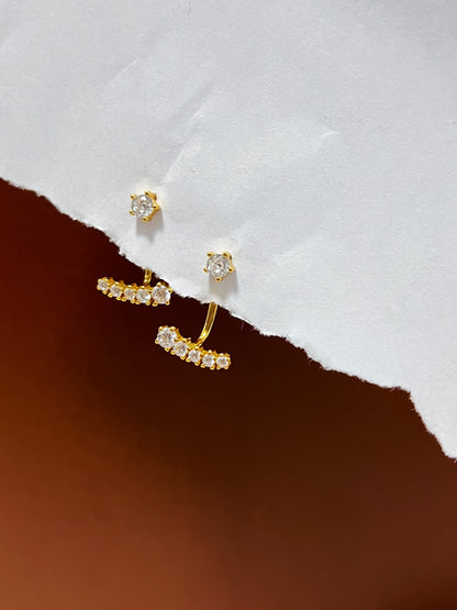 Gold jacket earrings with small cz diamonds on a white and brown background