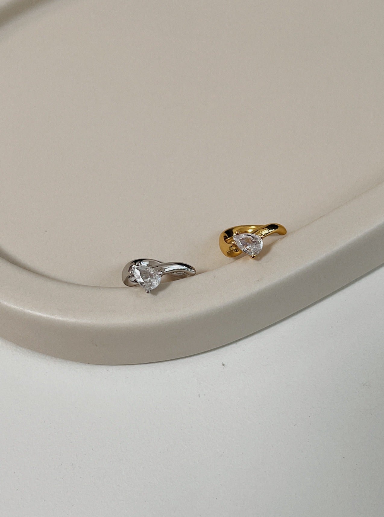 Close-up of Gold and Silver Teardrop Cuffs showing the pear-cut stone