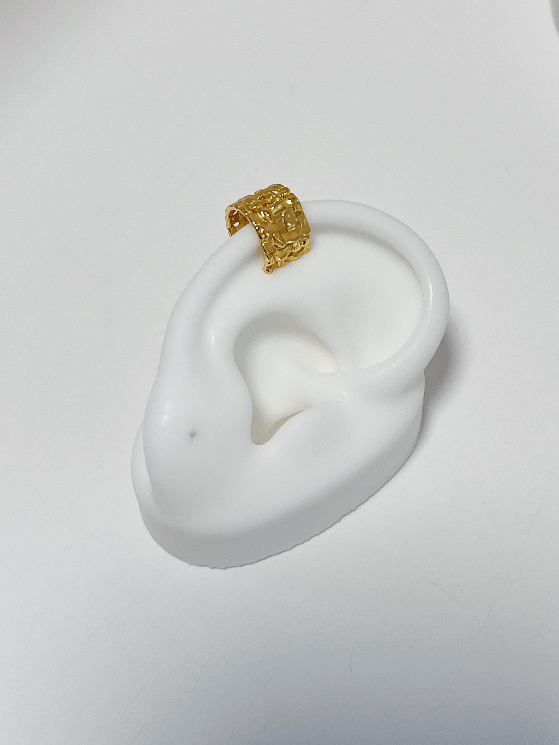 Close-up of white silicone ear featuring the 18k gold vermeil woven cuff.