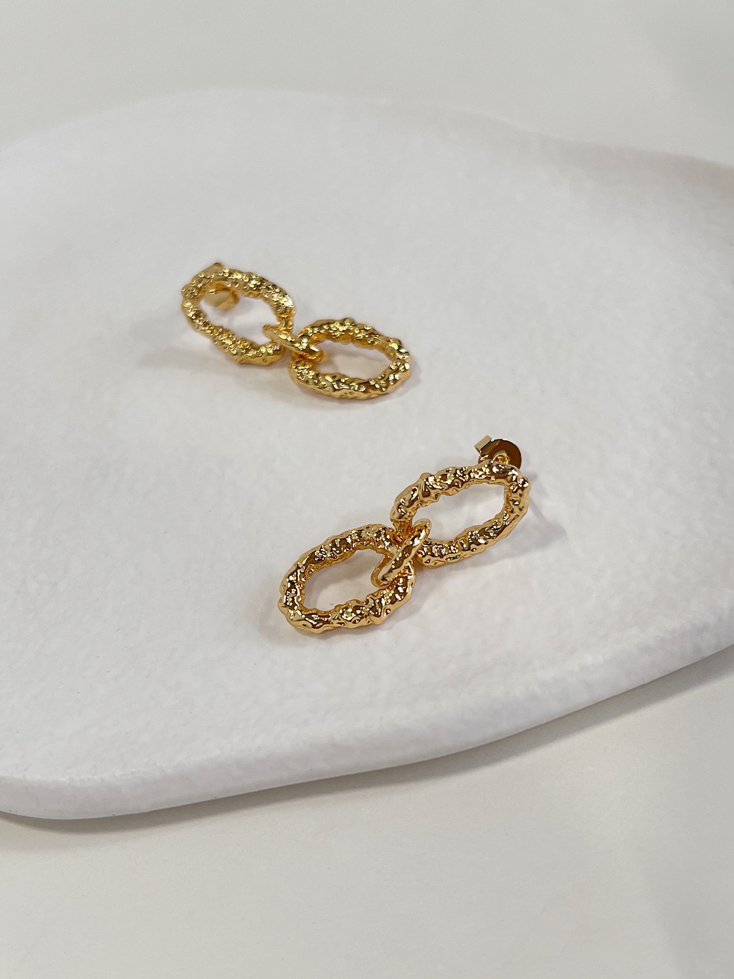 Two interlocking oval links cast in premium heavy gold plating over a structural brass core foundation