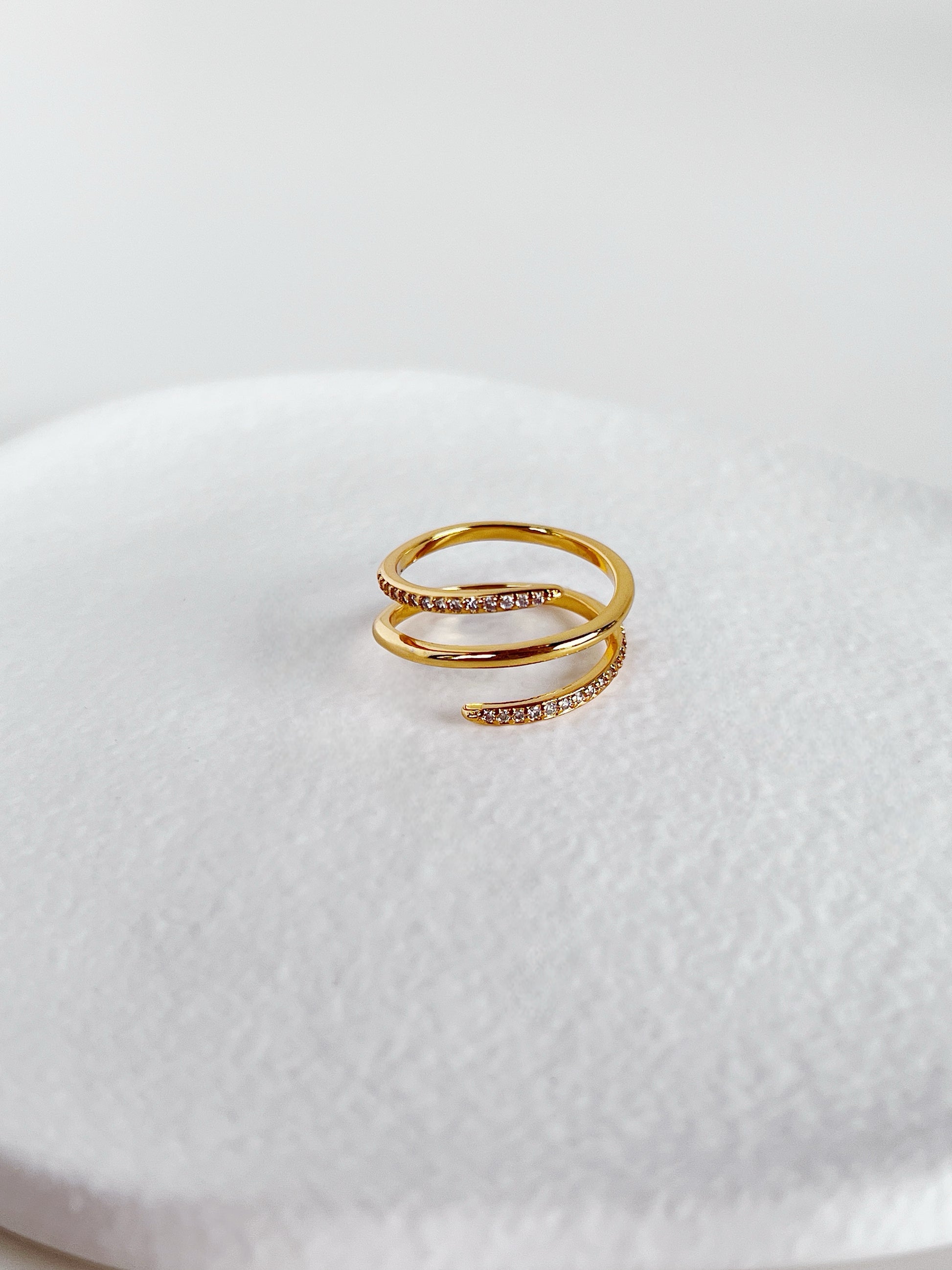 Gold ring with small diamonds on a white textured surface
