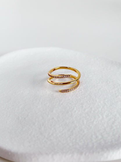 Gold ring with small diamonds on a white textured surface