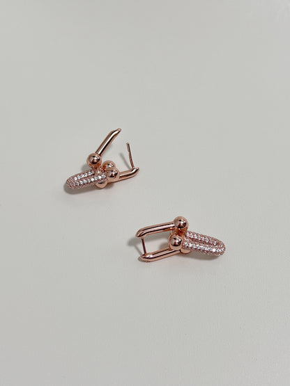 Luxury rose gold earrings with interlock design and set with pave diamond.