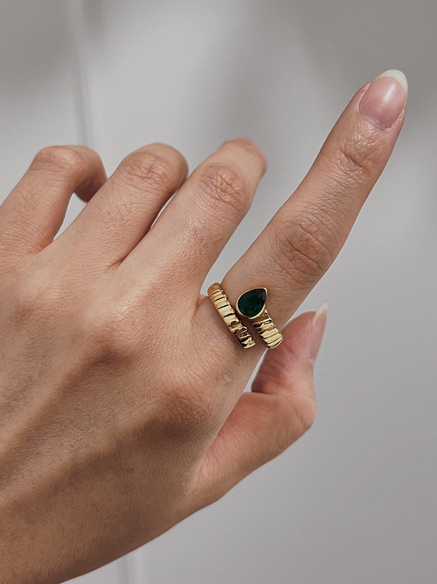 Elegant gold ring with emerald teardrop, ideal for weddings, engagements, and anniversaries.