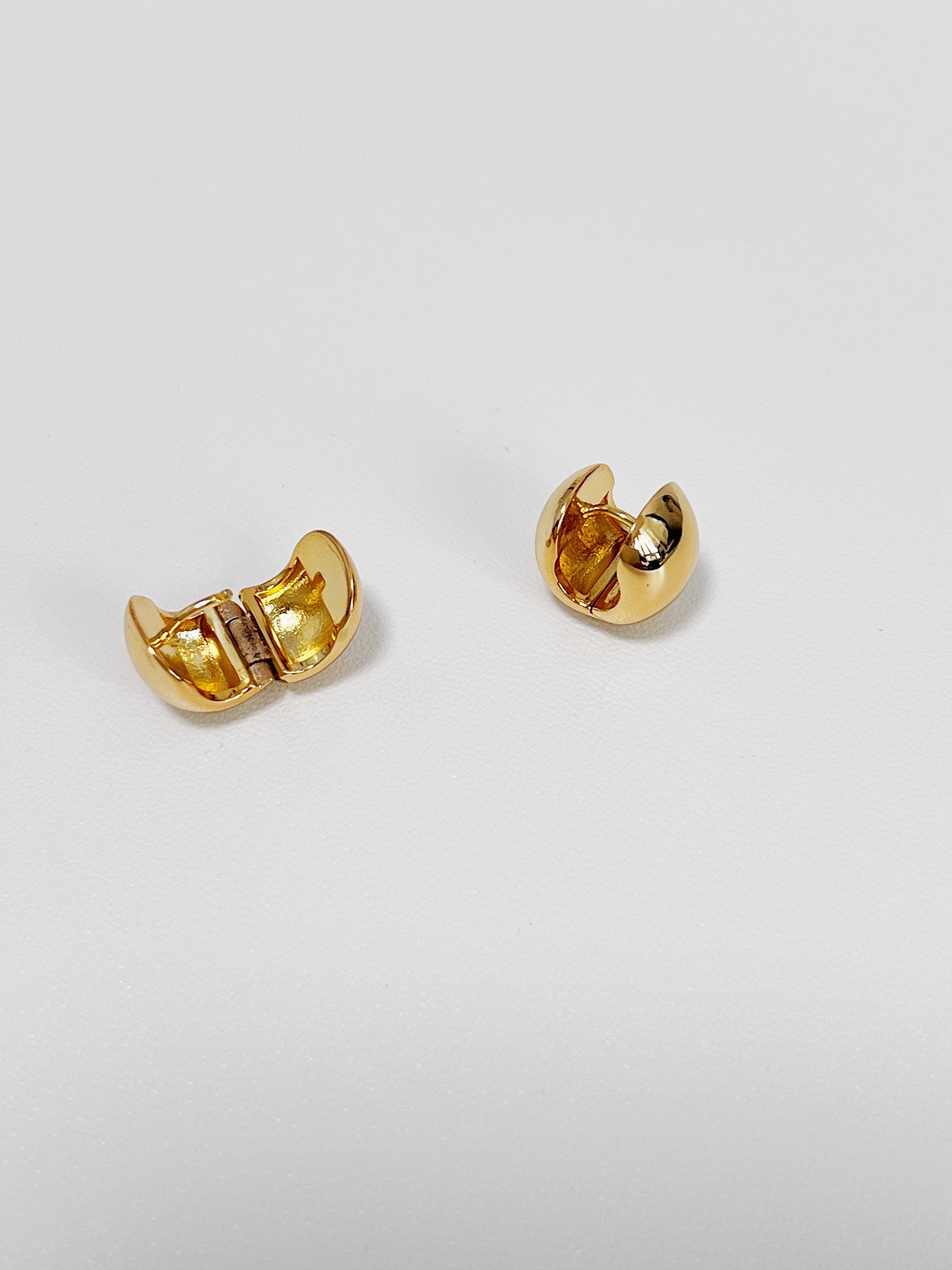 Pair of gold hoop earrings on a light gray background