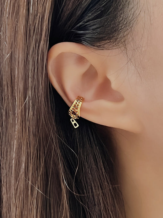 Gold zipper cuff earrings worn by a person with brown hair.