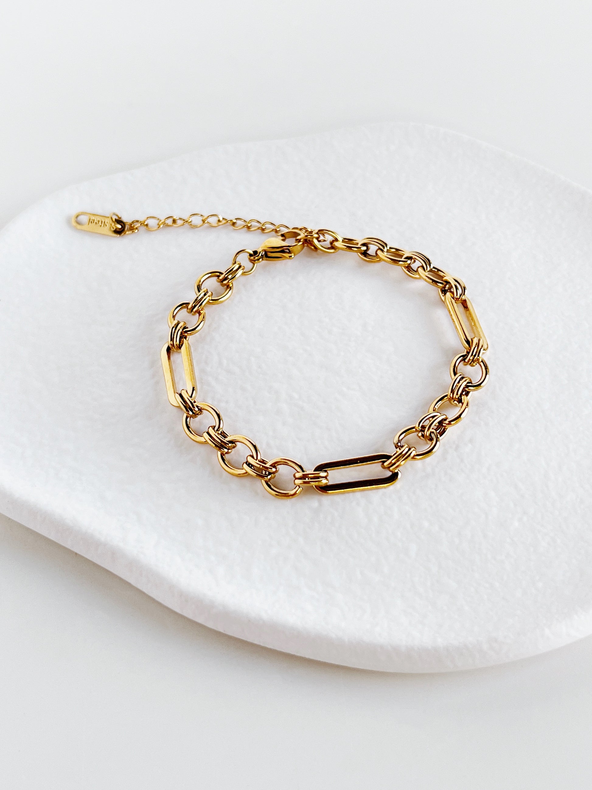 Gold chain bracelet on a white dish