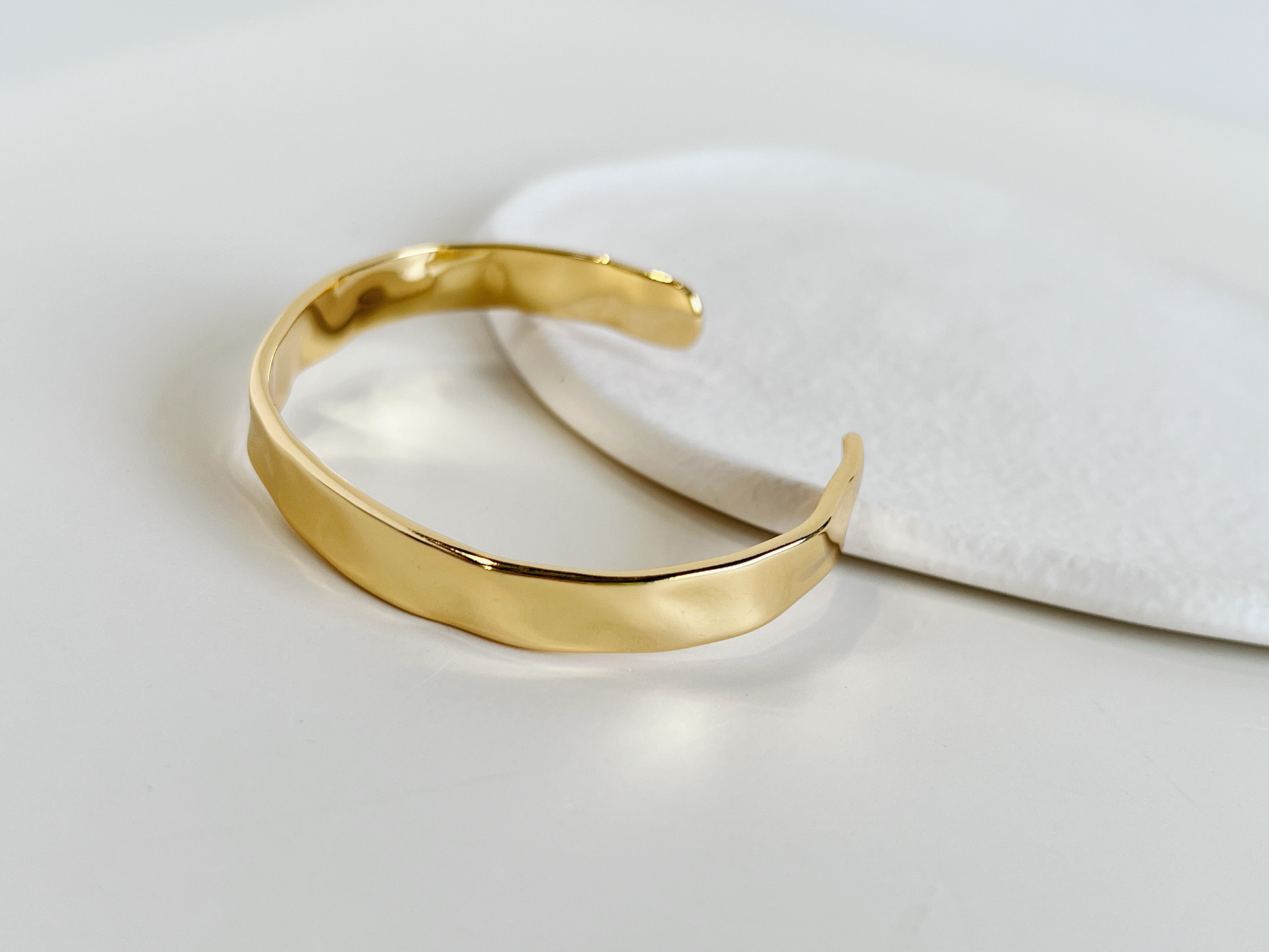 Elegant gold-colored open cuff bracelet, a versatile accessory for any occasion.