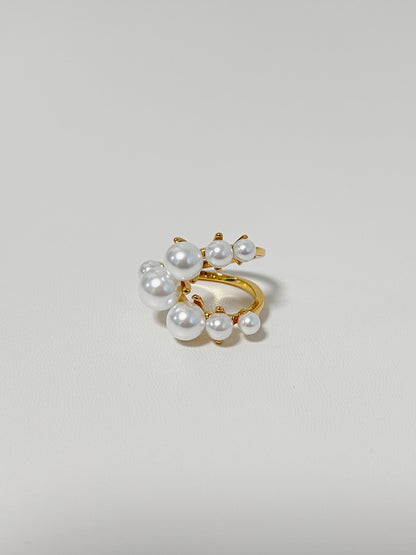 Gold ring with pearls on a light gray background