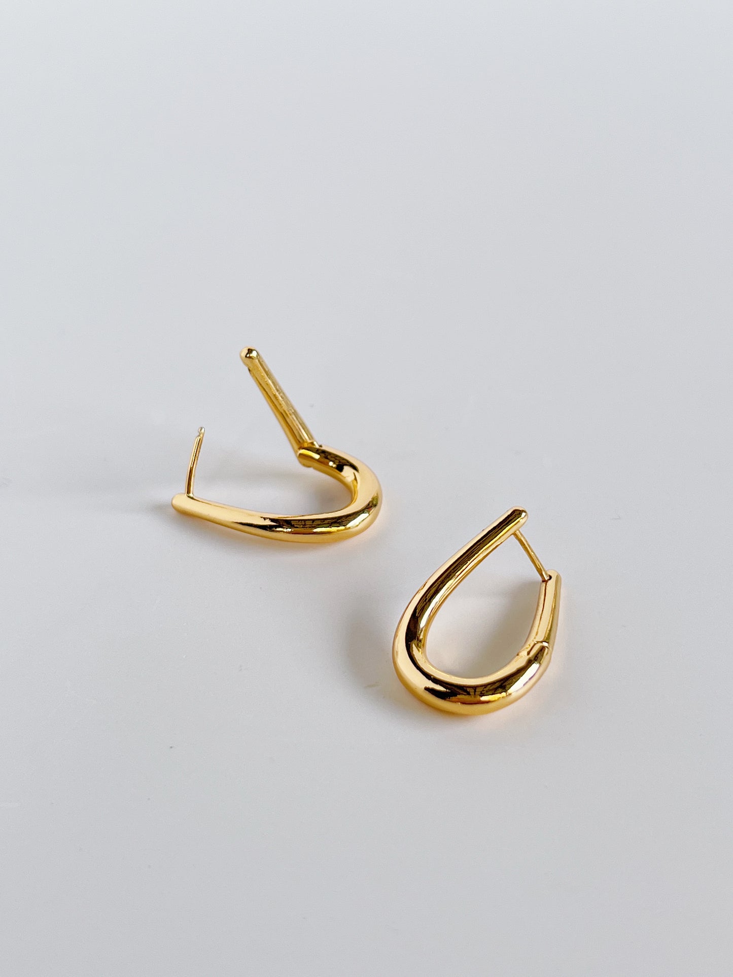 Gold hoop earrings on a light gray background