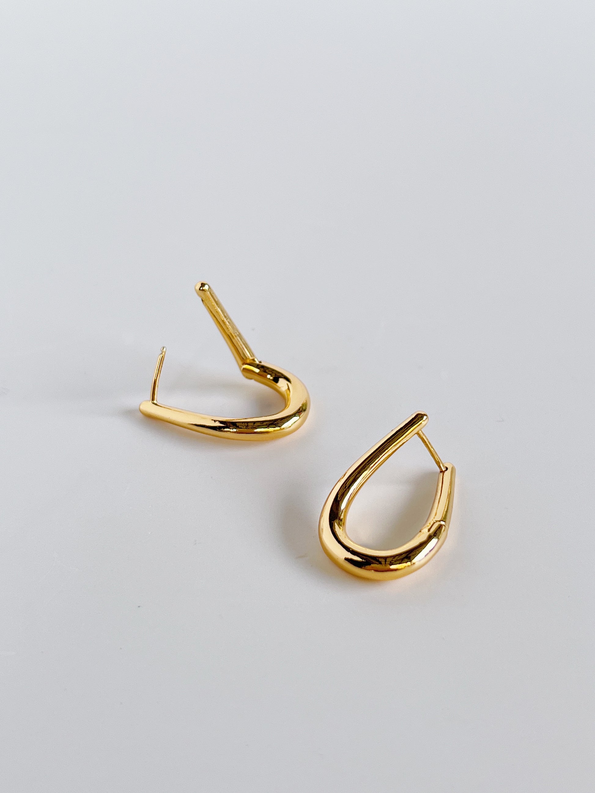 Gold hoop earrings on a light gray background