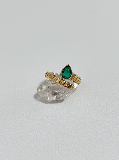 Elegant gold ring featuring a green teardrop gemstone, perfect for engagement or anniversary.