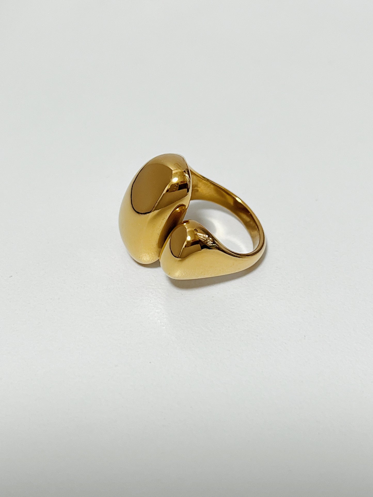 Gold statement ring on a light gray background