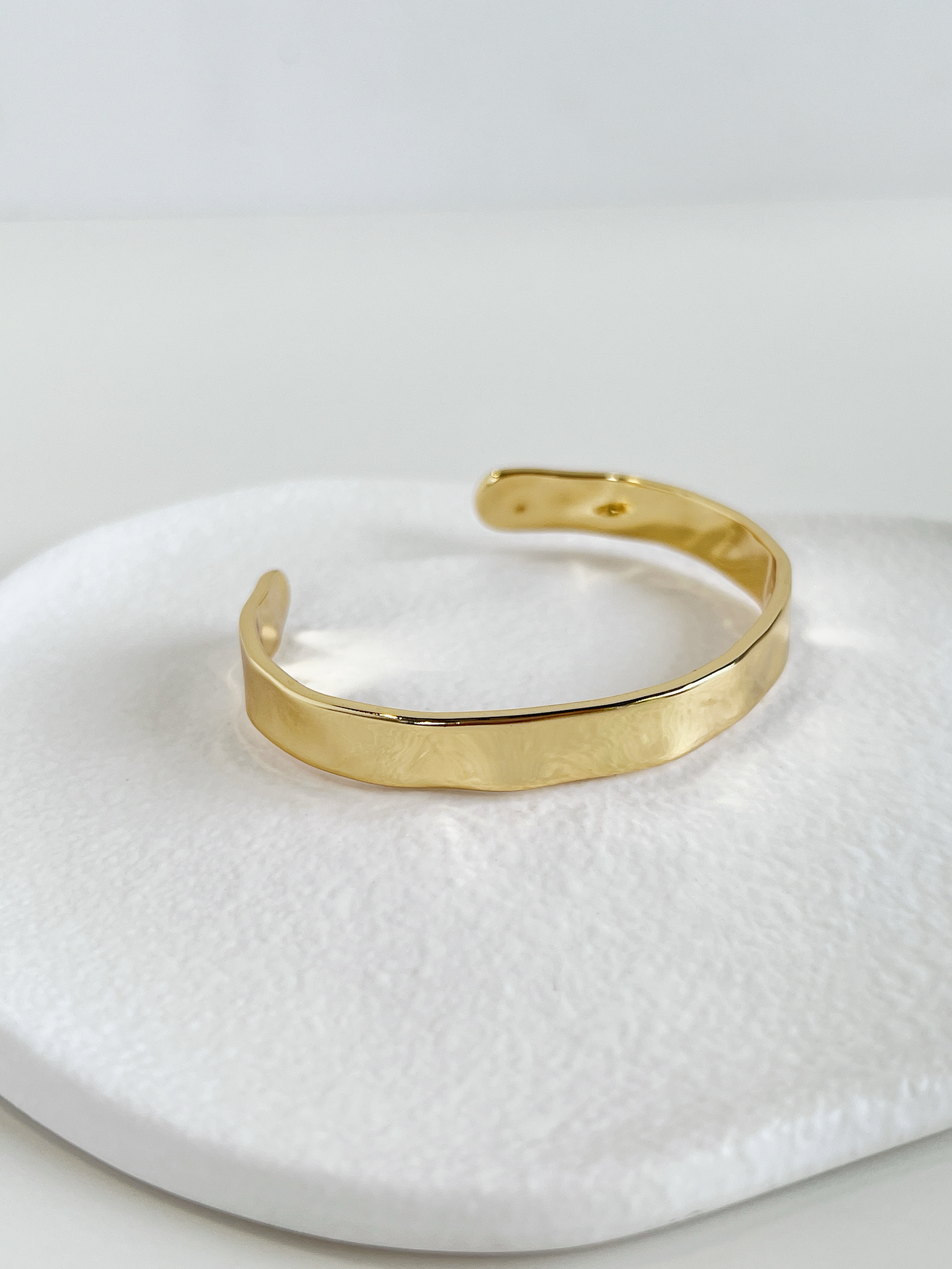 Chic and contemporary gold-tone cuff bangle, a timeless fashion statement.