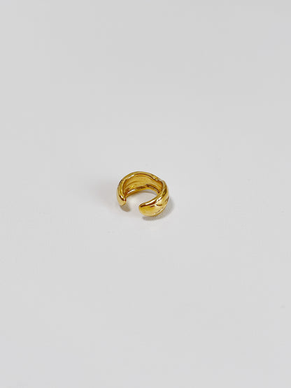 Gold ear cuff earrings on a light gray background