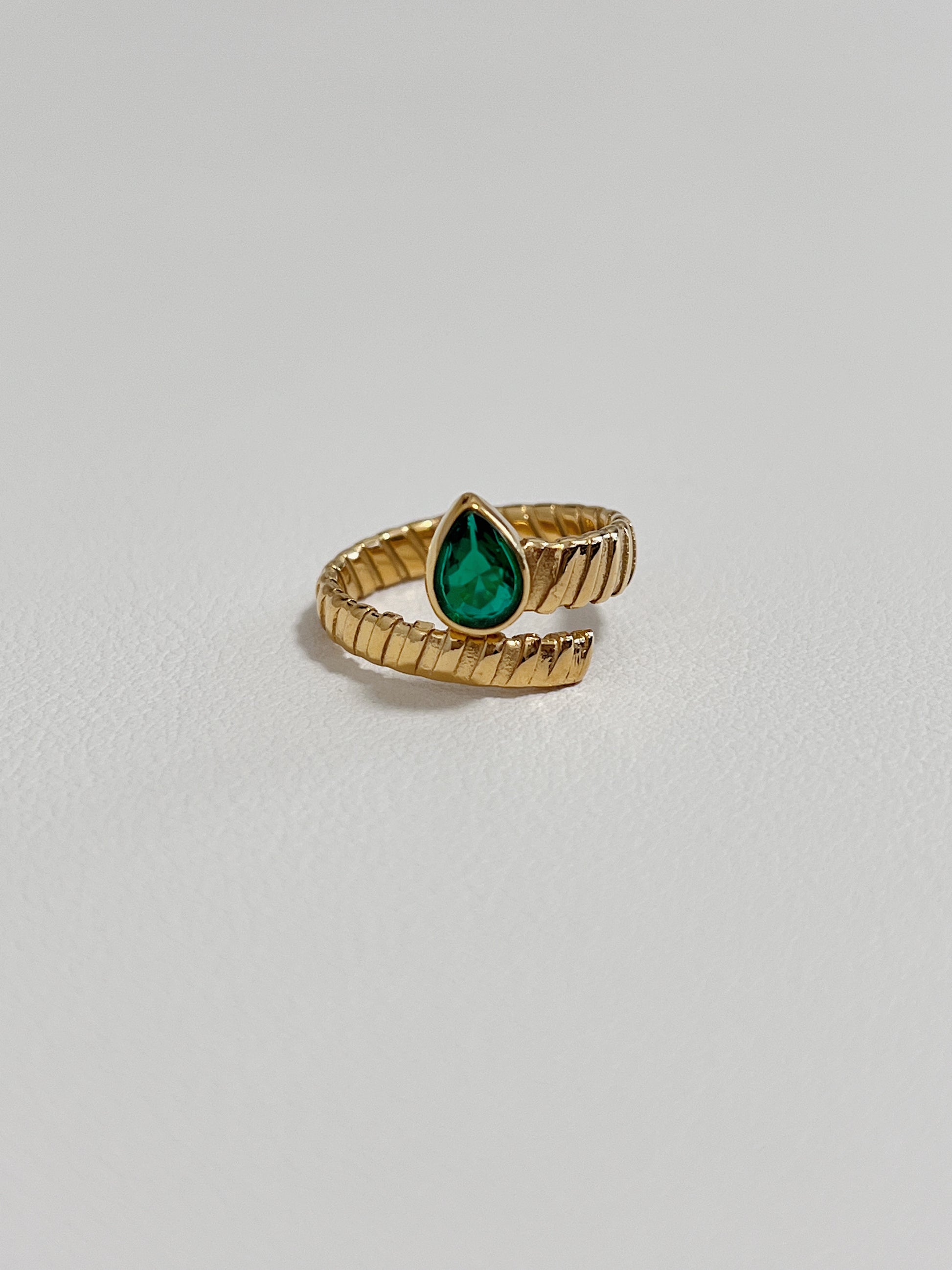 Gold ring with green teardrop gemstone, stylish and elegant, perfect for gifting.