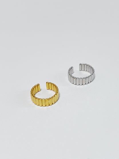 Two gold and silver ribbed ear cuff made of S925 sterling silver on a light gray background