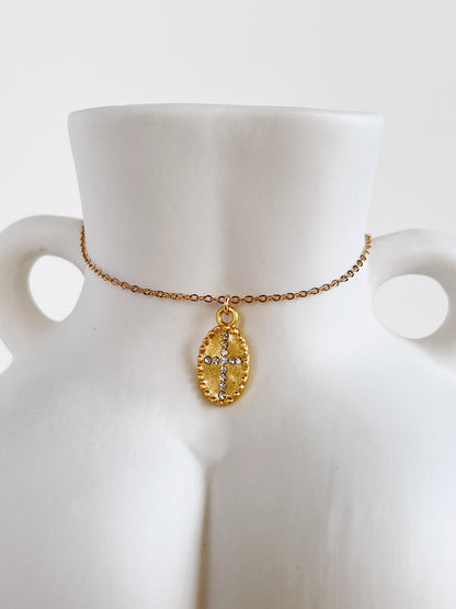 Close-up view highlighting the 5A cubic zirconia cross pendant of the Gianna necklace resting against the sculpted white ceramic body vase