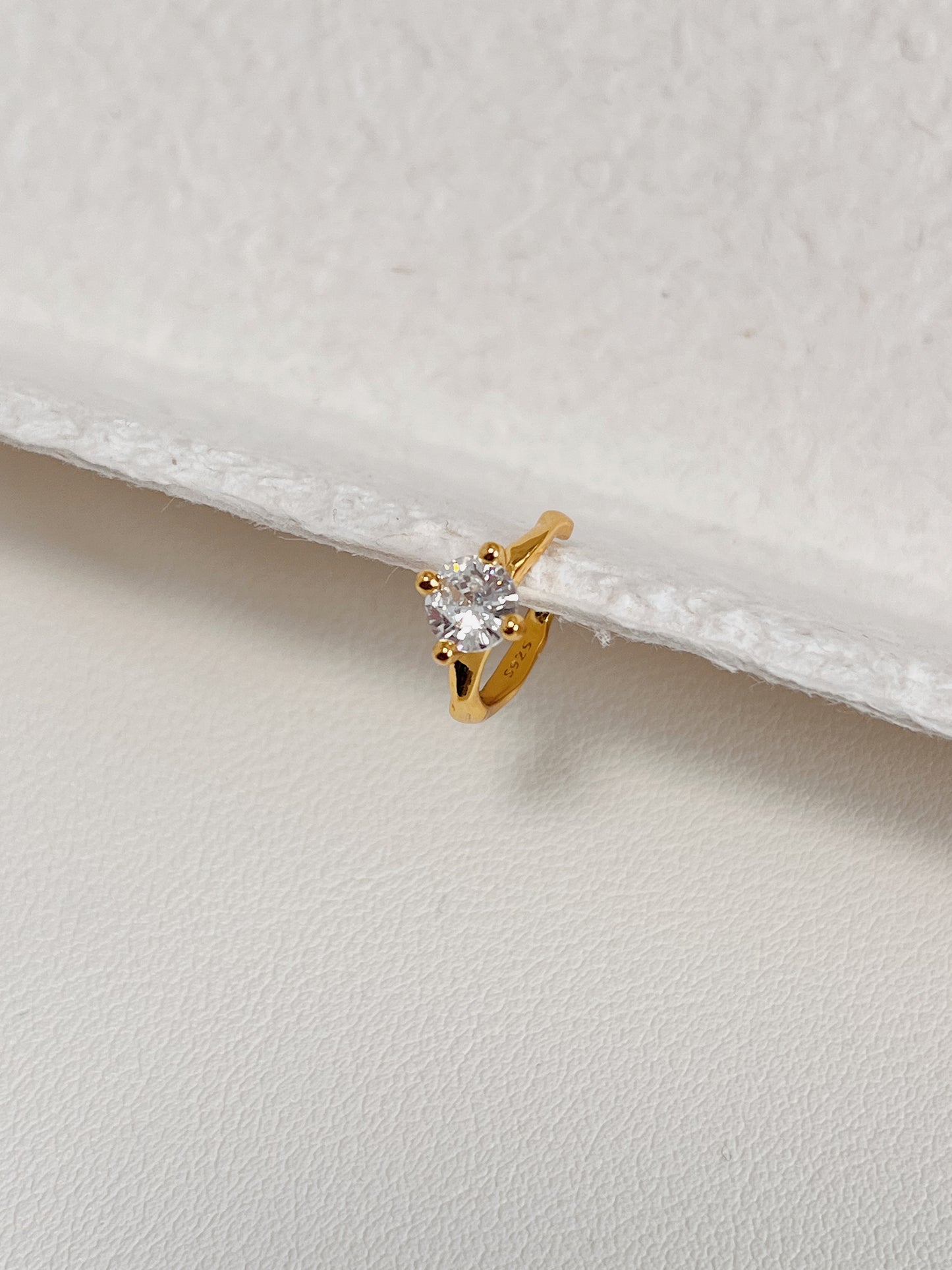 Side profile of minimalist gold ear cuff design.