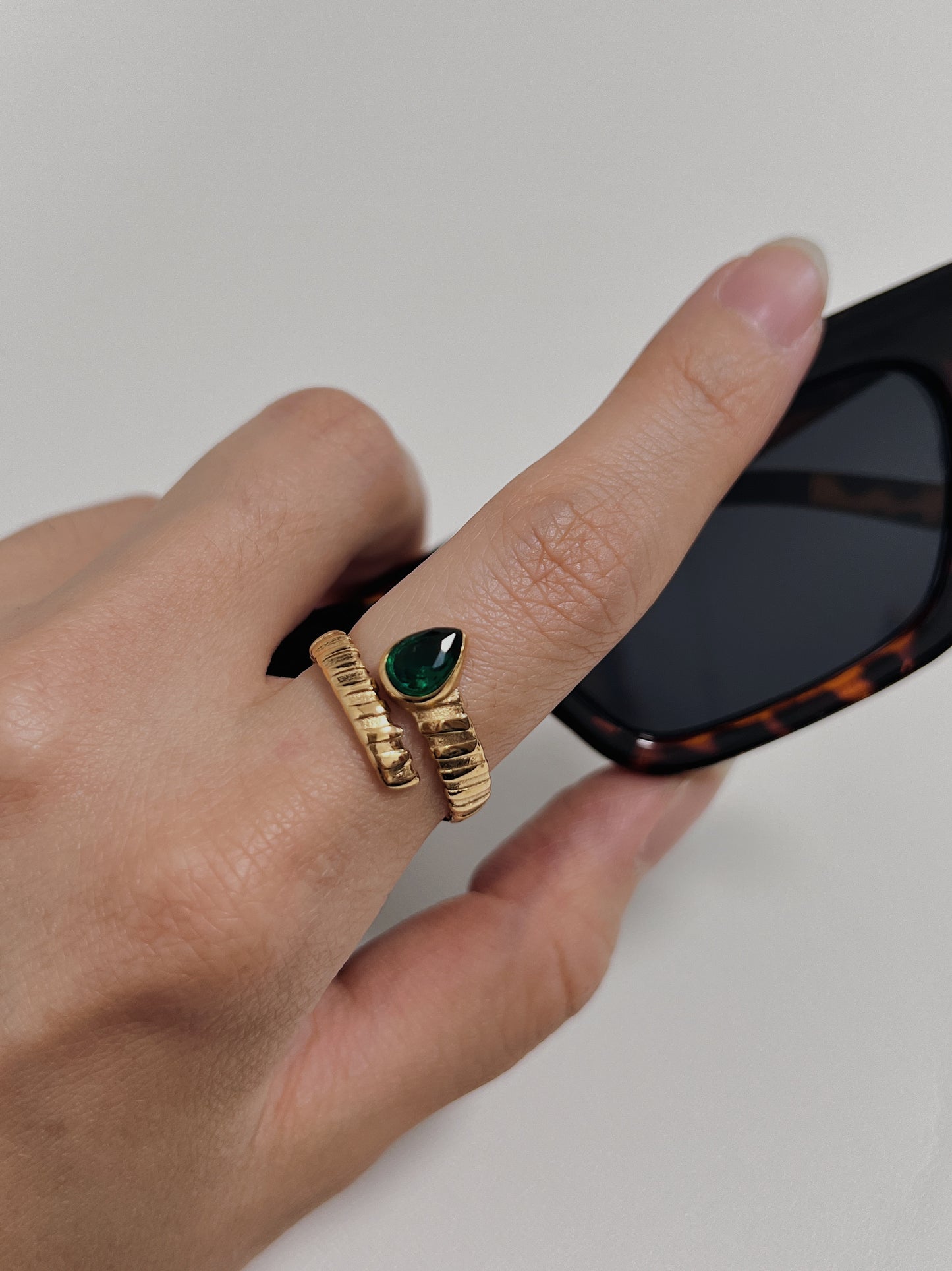 Gold ring with emerald teardrop, stylish and elegant, perfect for special occasions.