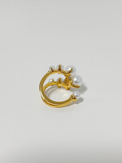 Gold ring with pearls on a light gray background
