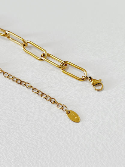Close up of the gold chain necklace's clasp on a white background