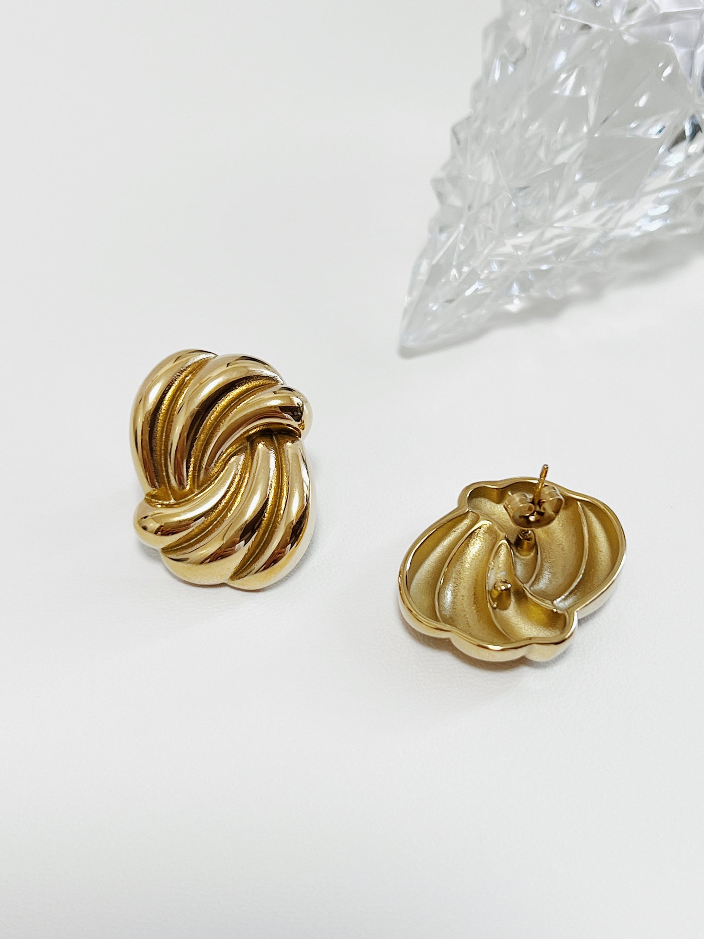 Gold knot earrings on a white background
