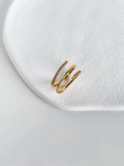 Gold ring with embedded stones on a white surface