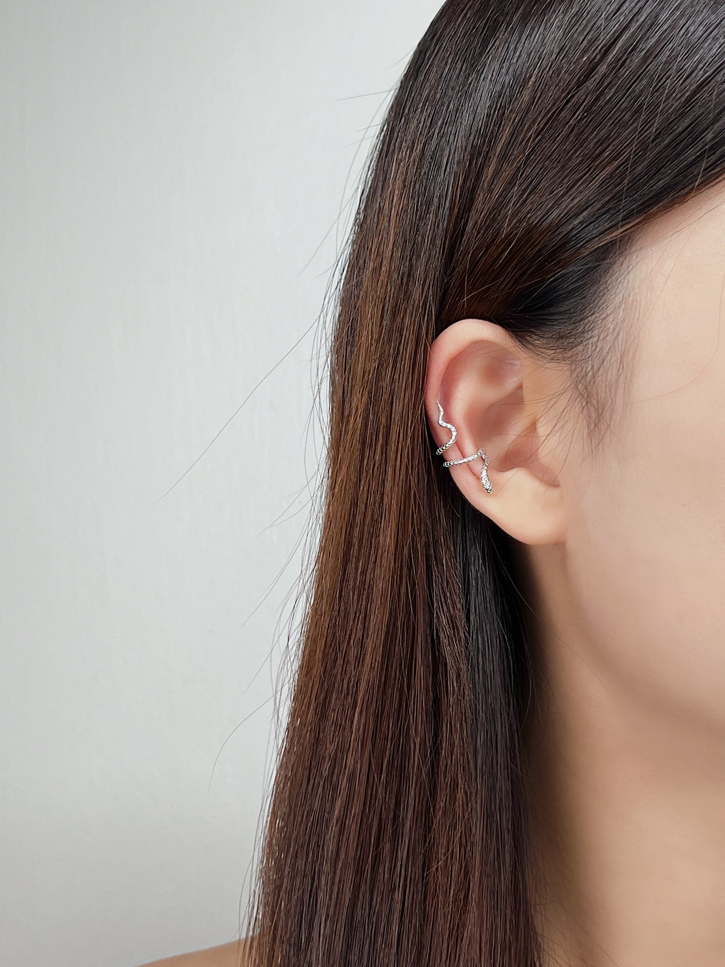 Close-up of model wearing victoria sterling silver snake ear cuff