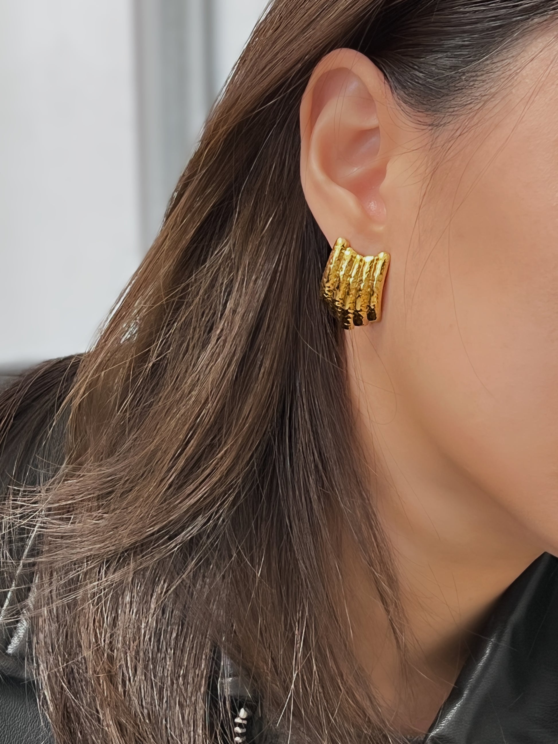 Trendy gold earrings with a ribbed and hammered design.